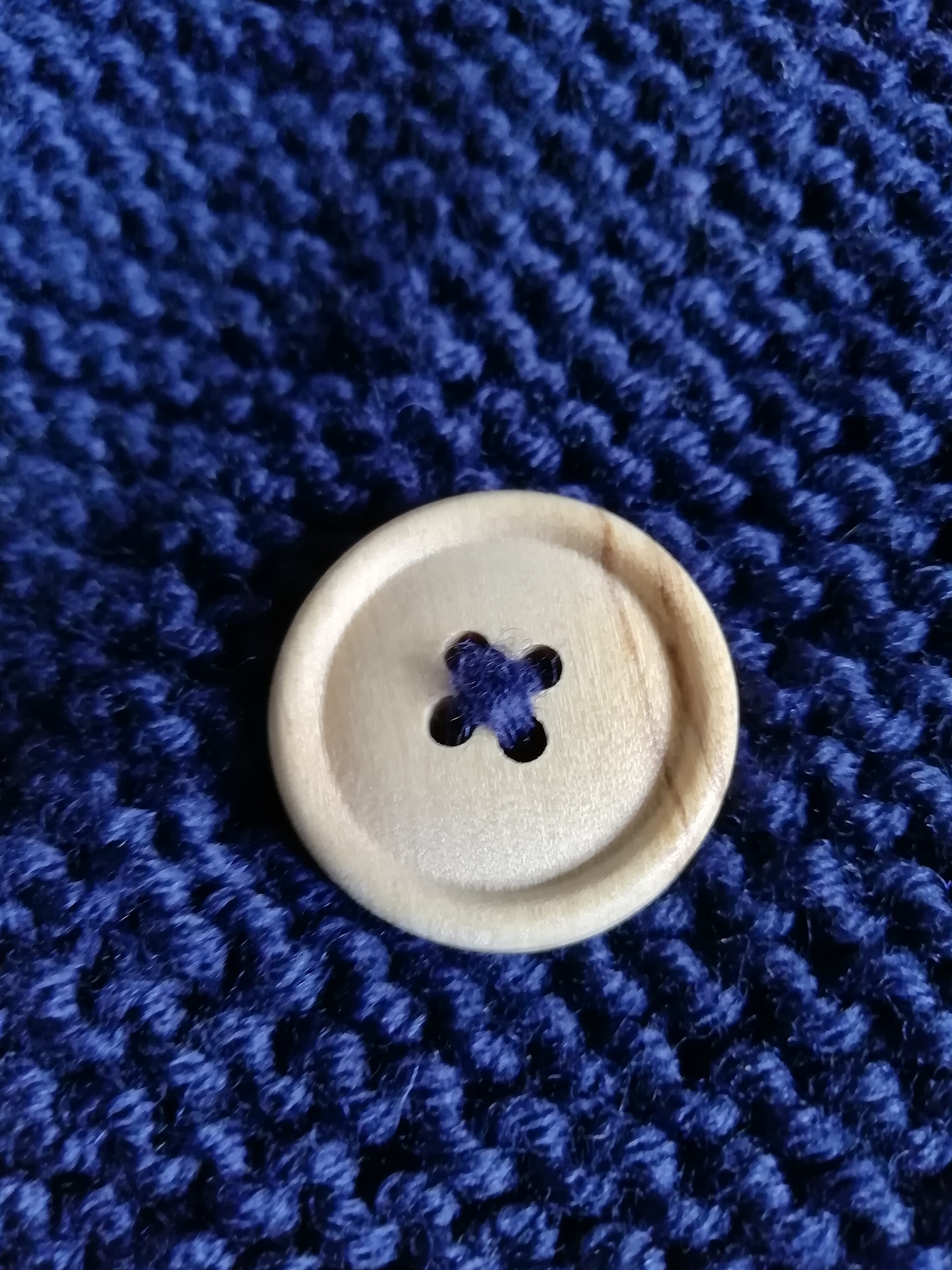 Wooden button against garter knitting