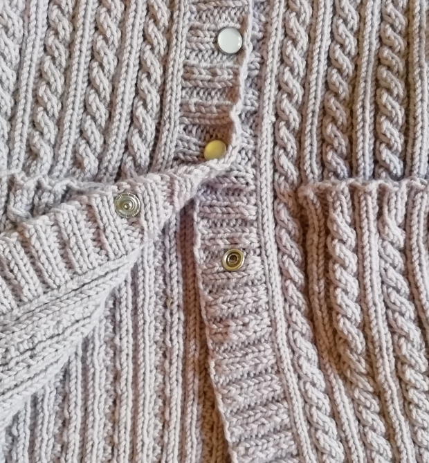 Detail of Cables and Poppers on baby cardigan